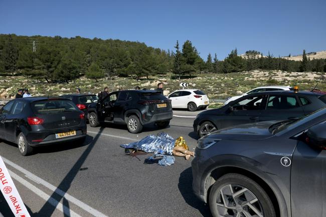 A body lies on the road near Maale Adumim Jewish settlement, east of Jerusalem, after a shooting attack that killed one person