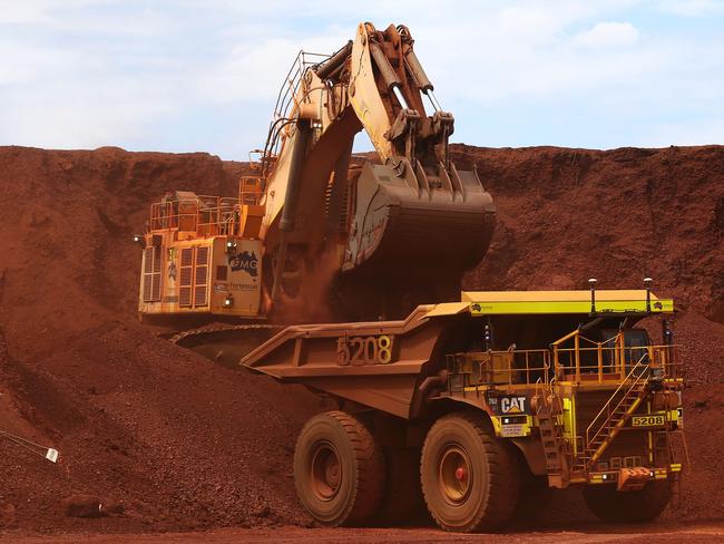 An excavator loads ore into an autonomous dump truck at Fortescue Metals Group Ltd.'s Solomon Hub mining operations in the Pilbara region, Australia, on Thursday, Oct. 27, 2016. Shares in Fortescue, the world's No. 4 iron ore exporter, have almost trebled in 2016 as iron ore recovered, and the company cut costs and repaid debt. Photographer: Brendon Thorne/Bloomberg