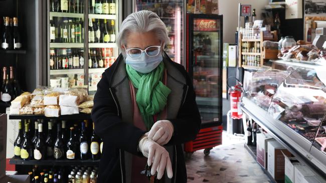 Italy has been one of the worst-hit countries. Here, a grocery store worker wears a protective mask and gloves before opening for business. Picture: Marco Di Lauro/Getty