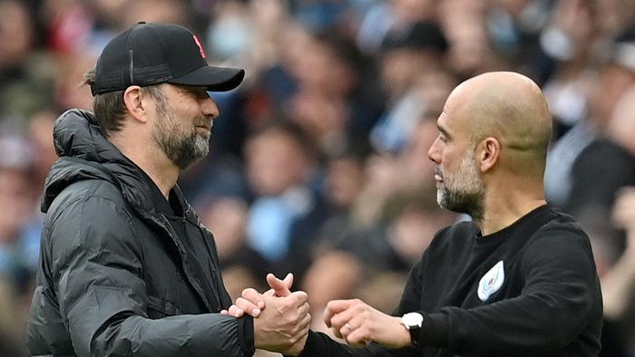 Liverpool's German manager Jurgen Klopp (L) shakes hands with Manchester City's Spanish manager Pep Guardiola after the English Premier League football match between Manchester City and Liverpool at the Etihad Stadium in Manchester, north west England, on April 10, 2022. – The match ended 2-2. (Photo by Paul ELLIS / AFP) / RESTRICTED TO EDITORIAL USE. No use with unauthorized audio, video, data, fixture lists, club/league logos or 'live' services. Online in-match use limited to 120 images. An additional 40 images may be used in extra time. No video emulation. Social media in-match use limited to 120 images. An additional 40 images may be used in extra time. No use in betting publications, games or single club/league/player publications. /