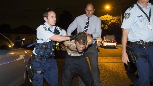 Police arrest a male at the scene of a homicide in Bankstown. Picture: Chris McKeen