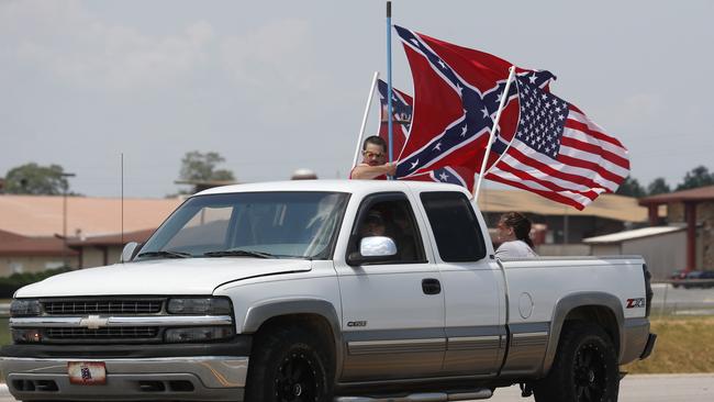 Despite the ban, race fans fly Confederate battle flags and a United States flag as they drive by Talladega Superspeedway prior to a NASCAR Cup Series auto race. Picture: AP