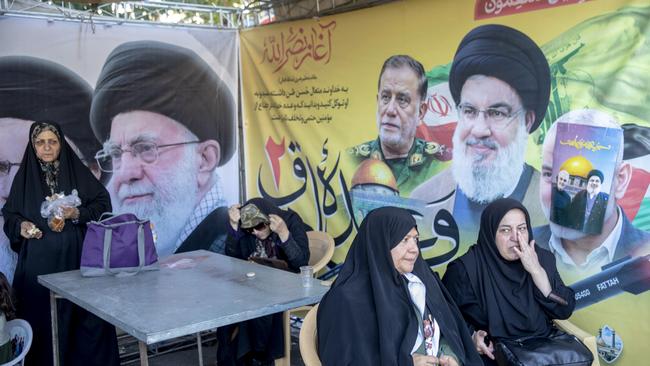 Iranians rest next to posters of the dead including Hassan Nasrallah after Friday prayers on October 13, 2013 in Tehran, Iran. Picture: Getty