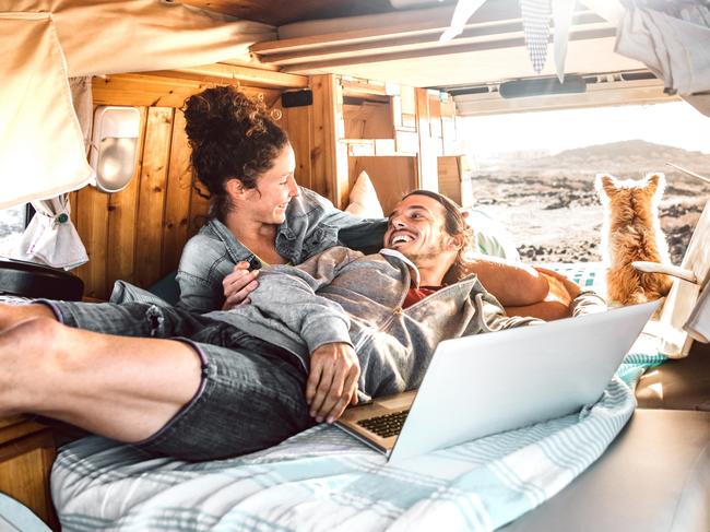 Hipster couple with dog traveling together on generic mini van transport - Digital nomad concept with indie people on minivan romantic trip working at laptop pc in relax moment - Warm contrast filtercredit: iStockescape19 september 2021doc holiday