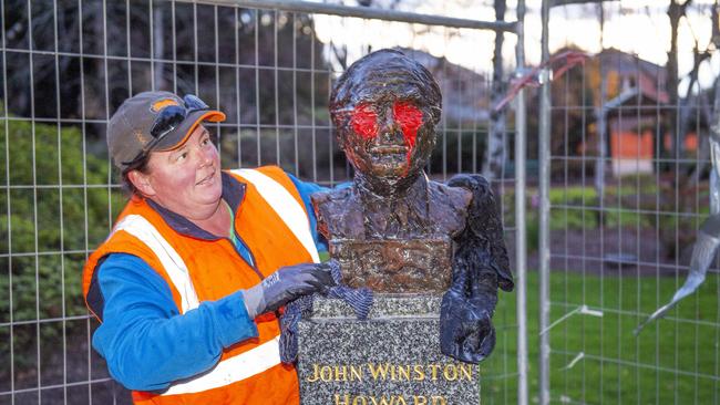 Council workers clean up the defaced statue of John Howard in Victoria. Picture: Rob Leeson