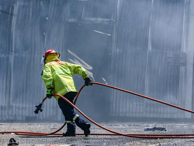 NTFES attend the scene the day after a massive blaze on College road in Berrimah. Picture: Glenn Campbell.