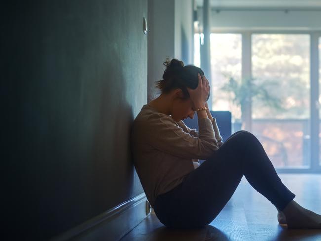 istock generic:  woman, abuse, DV, domestic violence, harassment, sexual harassment.   Sad Young Woman Sitting on the Floor In the Hallway of Her Appartment, Covering Face with Hands. Atmosphere of Depression, Trouble in Relationship, Death in the Family. Dramatic Bad News Moment . Picture: istock