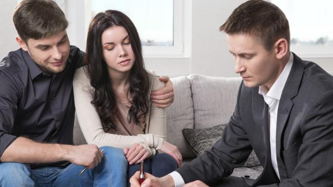 Agent advises the couple, signing documents.