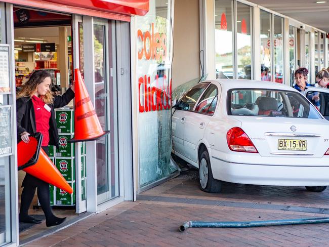 Coles crash: People assist an elderly driver who drove into the front door of Coles at Umina Beach. Picture: Gary Brown.