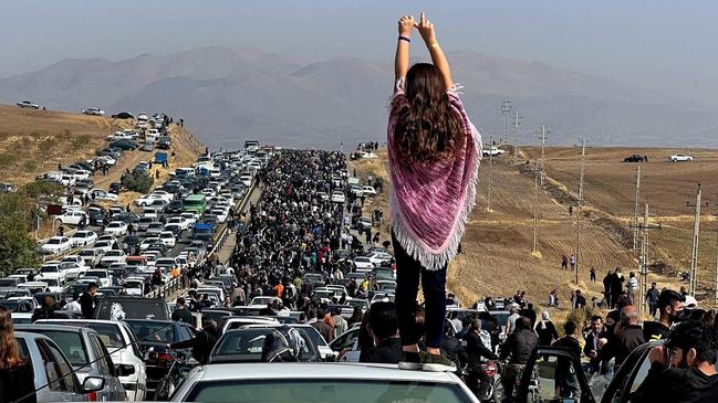 An unveiled woman stands on top of a vehicle as thousands make their way towards Aichi cemetery in Saqez, Mahsa Amini's home town in western Iran. Picture: Twitter/AFP