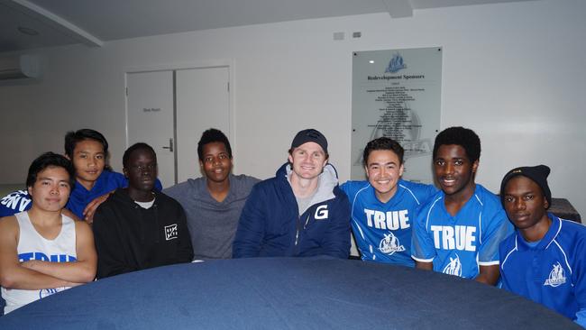 Patrick Dangerfield sits with Anglesea Football Club’s new recruits — children who have relocated to Australia. Picture: Geelong FC