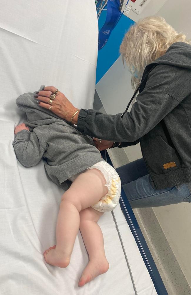 Baby Mia on an adult bed at Logan Hospital where she waited overnight to be diagnosed with a serious condition of the intestines. It is the same hospital where a month before, five-year-old Hiyaan Kapil died hours after being discharged while suffering stomach and leg pains in May.