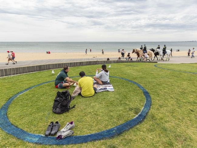 MELBOURNE, AUSTRALIA - NCA NewsWire Photos October 4, 2020:  People sit in social distancing circles at St Kilda beach in Melbourne, Victoria. Picture: NCA NewsWire / Daniel Pockett