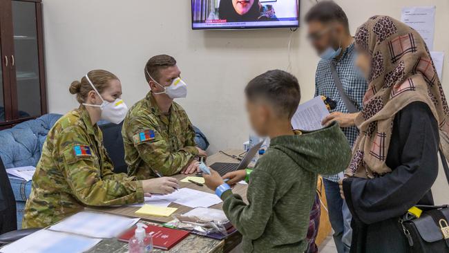 Australian Defence Force members of Joint Task Force 633 check in a family at the temporary camp in Australia’s main operating base in the Middle East. The camp will provide shelter to people evacuated from Kabul, Afghanistan prior to onward travel to Australia. Picture: Supplied/Australian Department of Defence