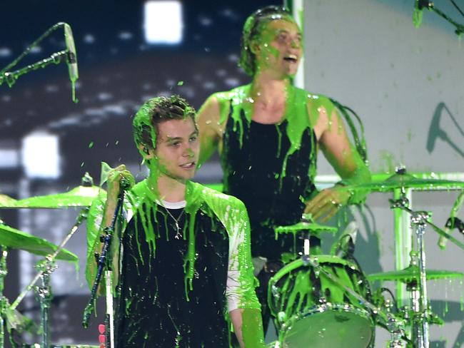 5 Seconds of Summer performs onstage after getting slimed.