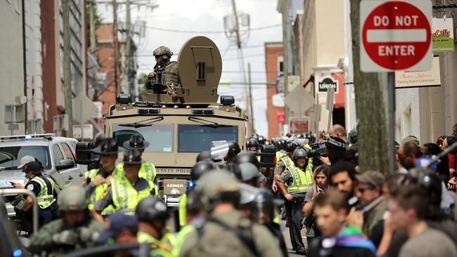 A Virginia State Police officer in riot gear keeps watch from the top of an armored vehicle after car plowed through a crowd of counter-demonstrators marching through the downtown shopping district August 12, 2017 in Charlottesville, Virginia after protesters clashed over the removal of a General Robert E. Leestatue. Picture: Getty Images