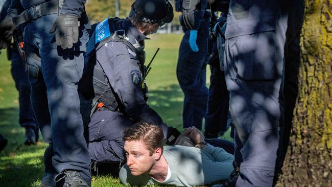 Police hold a protester on the ground at the Narre Warren oval. Picture: Tony Gough