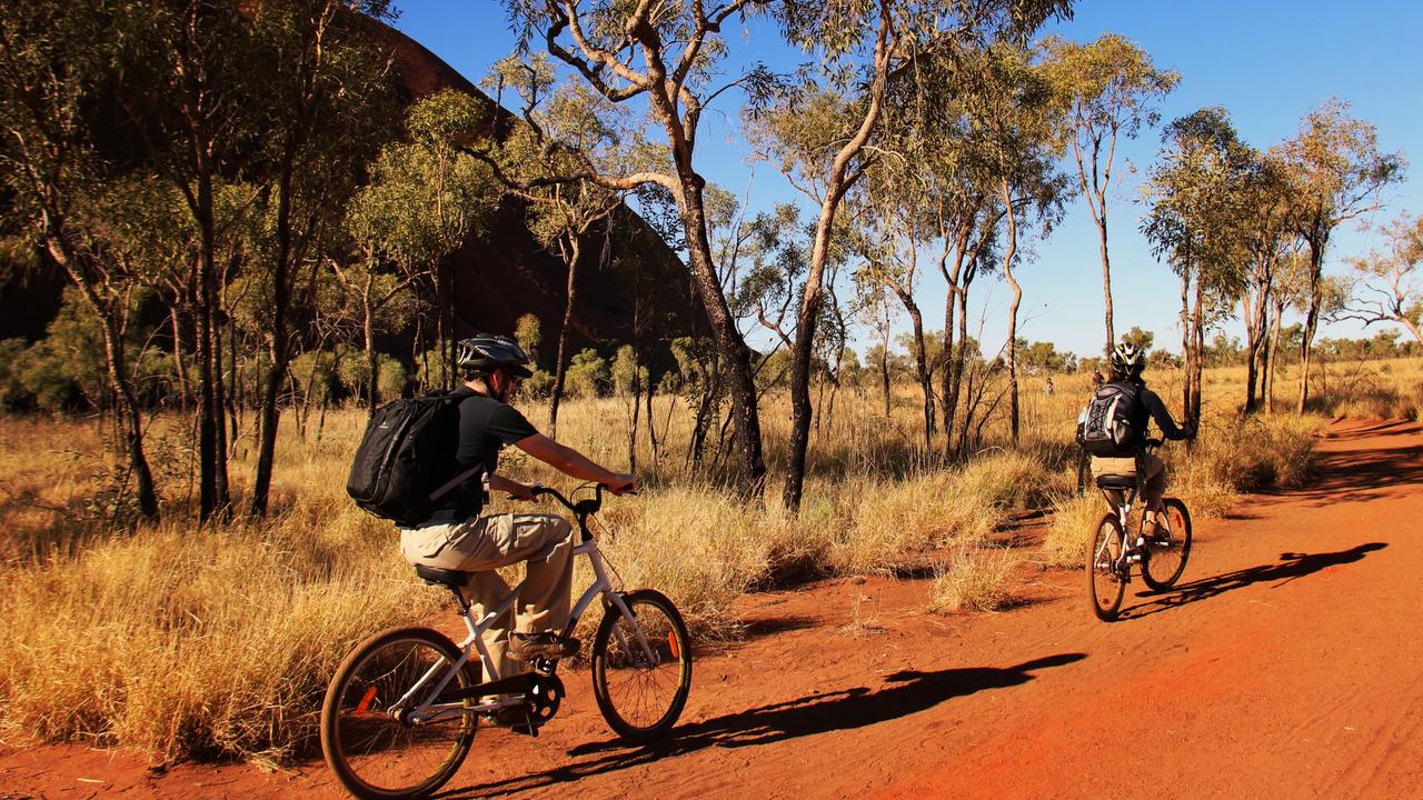 Kids News reader Macy loved riding a bike around Uluru, just like these tourists. Picture: Tourism NT