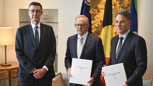 Sir Angus Houston, left, delivers the Defence Strategic Review 2023 to Prime Minister Anthony Albanese, centre, and Deputy PM and Defence Minister Richard Marles, right, at Parliament House in Canberra on February 14, 2023. Picture: Getty Images