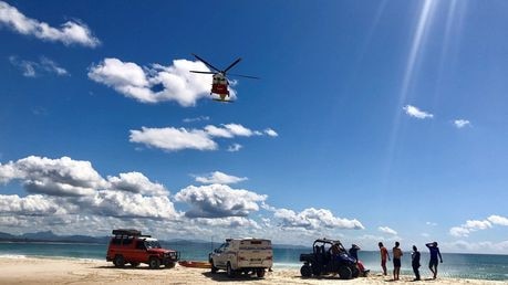 The Westpac Life Saver Rescue Helicopter prepares to winch a patient who was pulled from the ocean unconscious at Clarkes Beach. Picture: Christian Morrow.