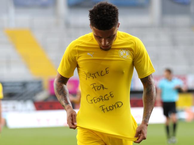 Dortmund's English midfielder Jadon Sancho shows a "Justice for George Floyd" shirt as he celebrates after scoring his team's second goal during the German first division Bundesliga football match SC Paderborn 07 and Borussia Dortmund at Benteler Arena in Paderborn on May 31, 2020. (Photo by Lars Baron / POOL / AFP) / DFL REGULATIONS PROHIBIT ANY USE OF PHOTOGRAPHS AS IMAGE SEQUENCES AND/OR QUASI-VIDEO