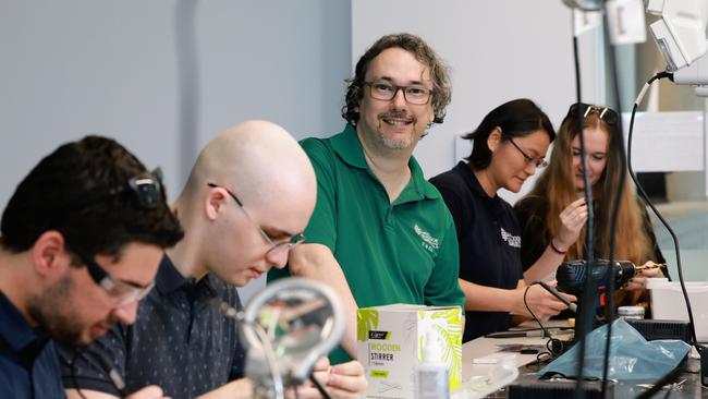 James Cook University IT lecturer Jason Holdsworth (centre) helps his students with their research projects in the JCU Ideas Lab at the Smithfield campus. Picture: Brendan Radke