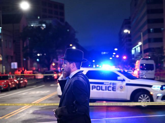 A man, standing behind police tape, talks on his phone outside the Capital Jewish Museum following a shooting that left two people dead, in Washington, DC. Picture: AFP