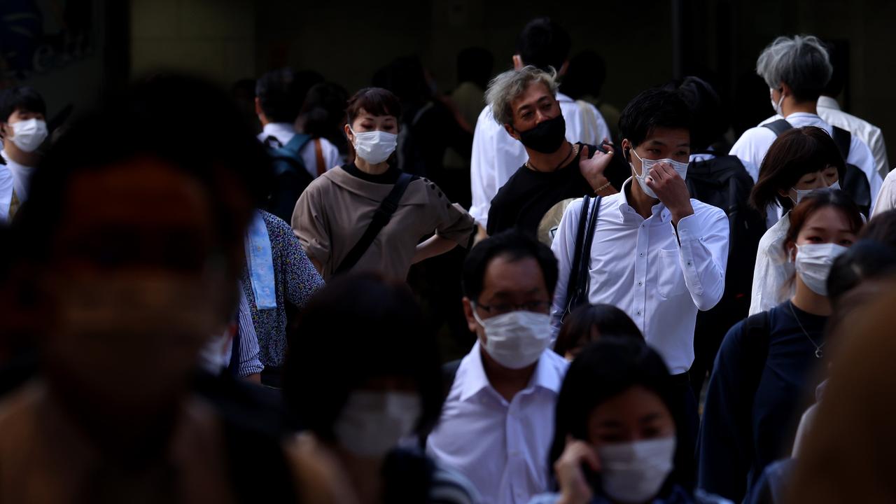 Pedestrians, wearing face masks, cross a road during morning rush hour in Osaka, Japan. Picture: Buddhika Weerasinghe/Getty Images