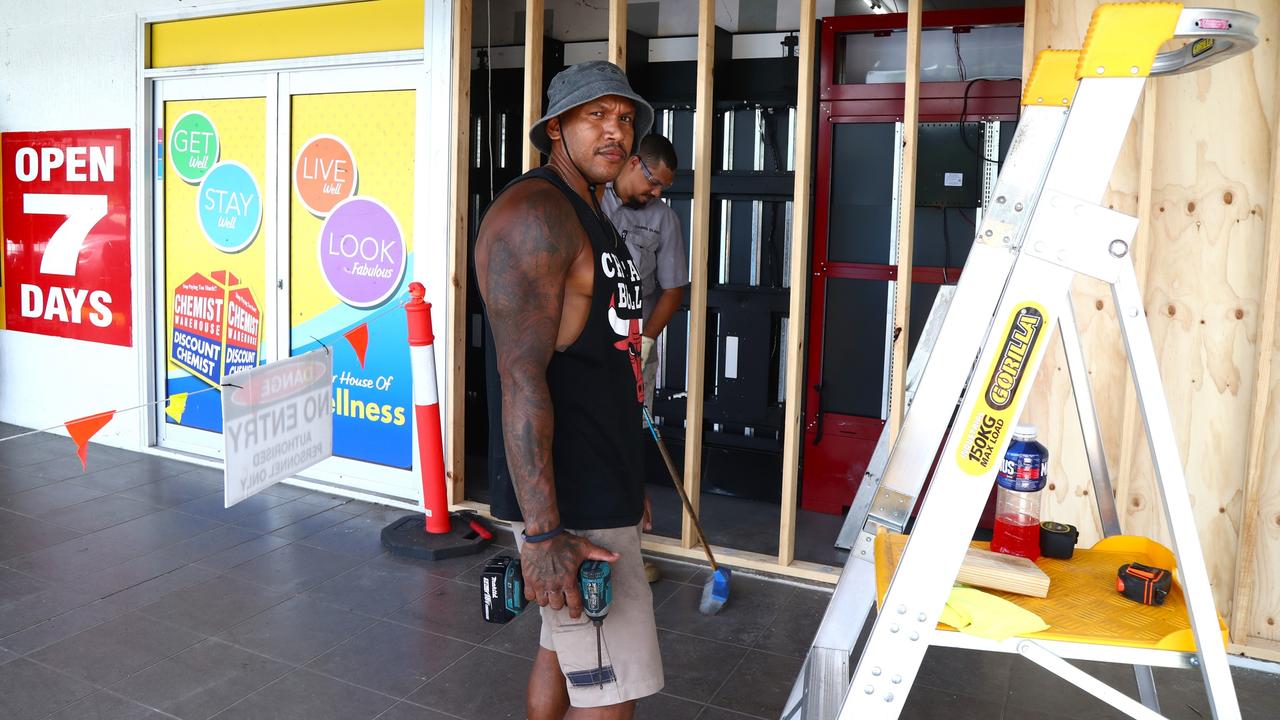 Cairns Glass and Glazing worker Cjaay Ahwang install temporary plywood boards at the Bentley Park Chemist Warehouse after the shopfront was ram raided on Sunday night. Picture: Peter Carruthers