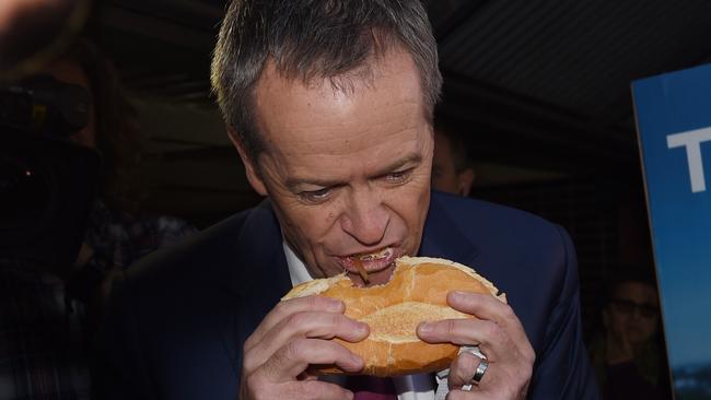 Now this is truly careless consumption of a sausage and onion sanga. Picture: AAP/Mick Tsikas