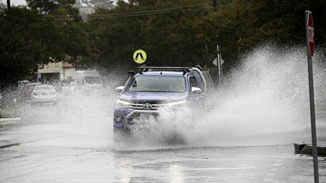 Cars drive through a flooded Illawarra Rd at Marrickville on Saturday morning. Picture: Adam Yip