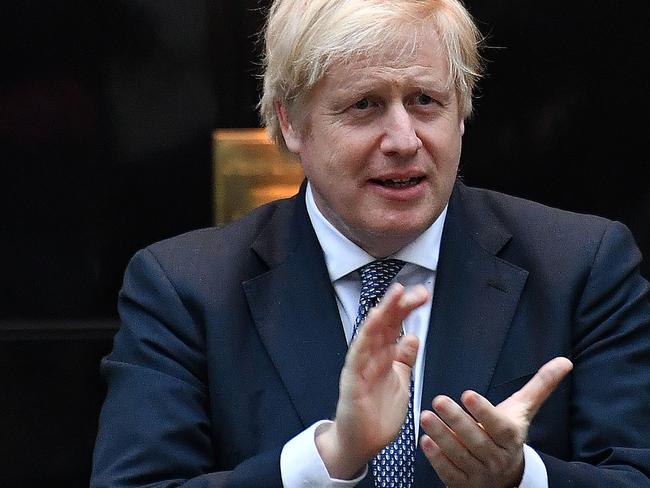 Britain's Prime Minister Boris Johnson participates in a national "clap for carers" to show thanks for the work of Britain's NHS (National Health Service) workers and other frontline medical staff around the country as they battle with the novel coronavirus pandemic, in the doorway of 10 Downing Street in central London on April 30, 2020. - ˜Britain is "past the peak" of its coronavirus outbreak, Prime Minister Boris Johnson said Thursday, despite recording another 674 deaths in the last 24 hours, taking the toll to 26,711. "For the first time, we are past the peak of this disease... and we are on the downward slope," Johnson said in his first media briefing since returning to work following his own fight against the virus. (Photo by Ben STANSALL / AFP)