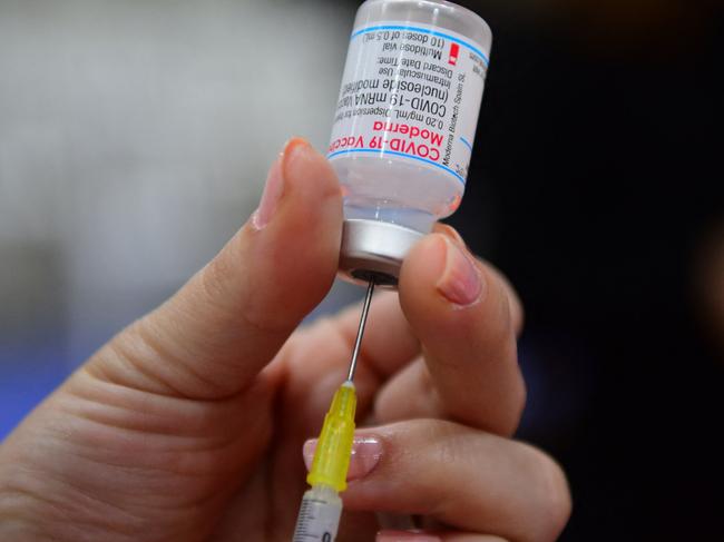 A health worker prepares a dose of the Moderna vaccine against COVID-19 at the National Secretary of Sports vaccination centre in Asuncion, Paraguay on June 19, 2021. (Photo by NORBERTO DUARTE / AFP)