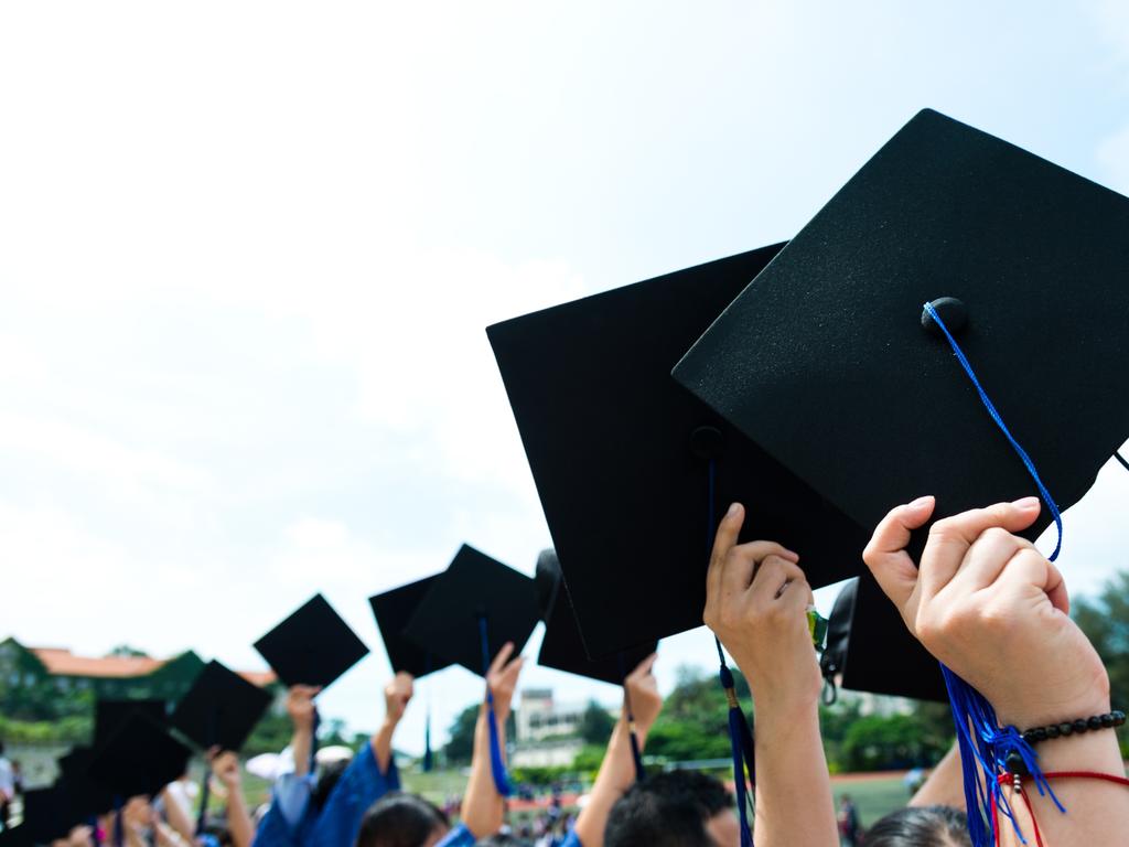 Group of graduate students holding their graduation hats.