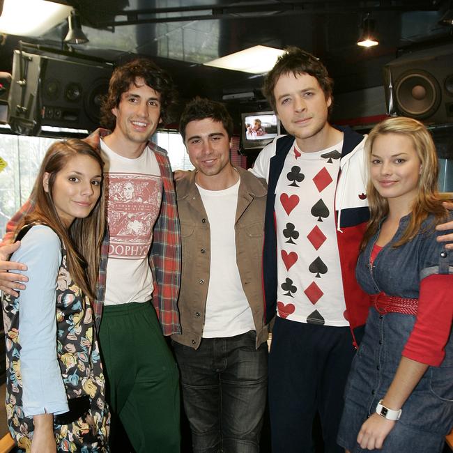 Radio hosts Hamish Blake and Andy Lee film a scene for TV show Neighbours at Fox FM Studios, St Kilda. (L to R) Caitlin Stasey (Neighbours actor), Andy Lee, Nick Anderson, Hamish Blake and Margot Robbie (Neighbours actor).