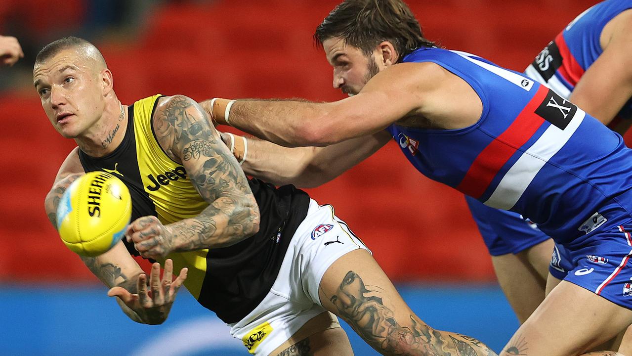 Dustin Martin of the Tigers clears as he is tackled by Josh Bruce of the Bulldogs . Pic: Michael Klein