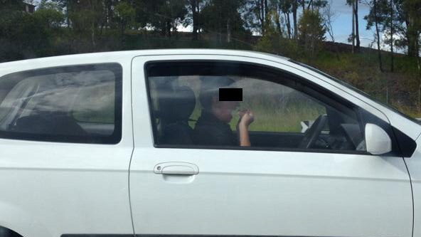 A passenger snapped this pic of a woman flossing with both hands while driving on the M1 at Yatala. Photo supplied