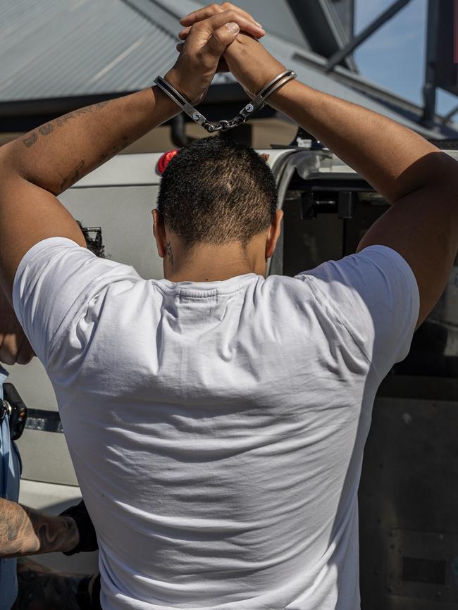 A man is arrested and handcuffed.