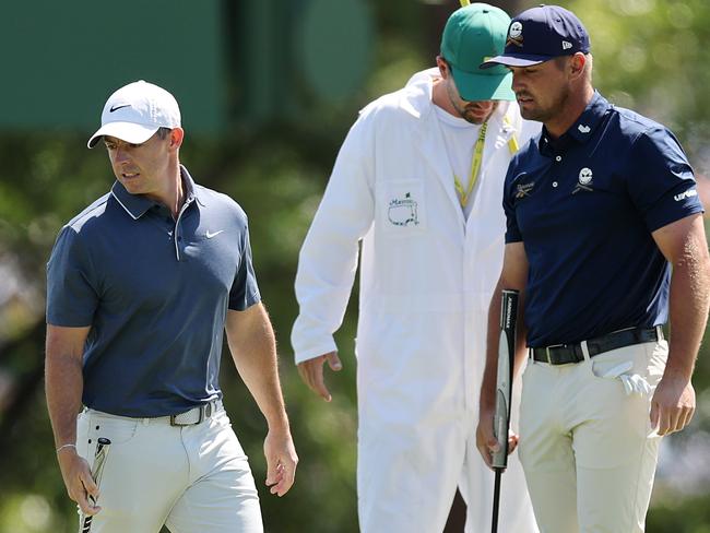 AUGUSTA, GEORGIA - APRIL 13: (R-L) Bryson DeChambeau of the United States and Rory McIlroy of Northern Ireland line up putts on the third green during the final round of the 2025 Masters Tournament at Augusta National Golf Club on April 13, 2025 in Augusta, Georgia. (Photo by Michael Reaves/Getty Images)