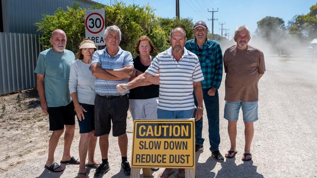 Ian Williams (third from right) with fellow residents on Ti-Tree Rd, one of the town’s three main thoroughfares, just after a car has driven past. Picture: Naomi Jellicoe