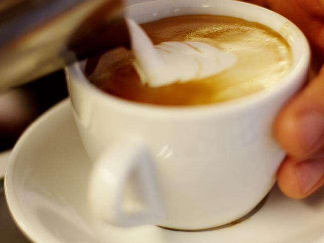 Sweden, Vastra Gotaland, Goteborg, Barista pouring warm milk into coffee