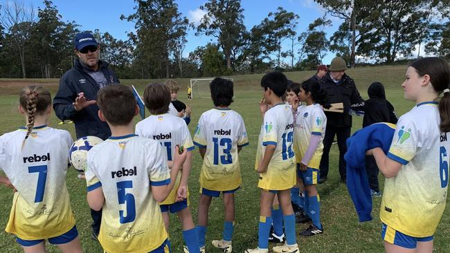 The USQ 2024 under-11 Blue team during half time of a game.