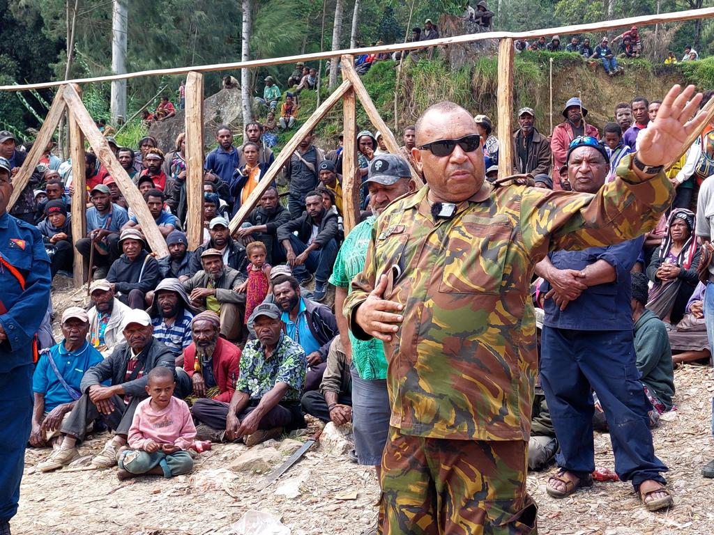 Papua New Guinea's Defence Force officer Michael Band talks to locals at the site the landslide.