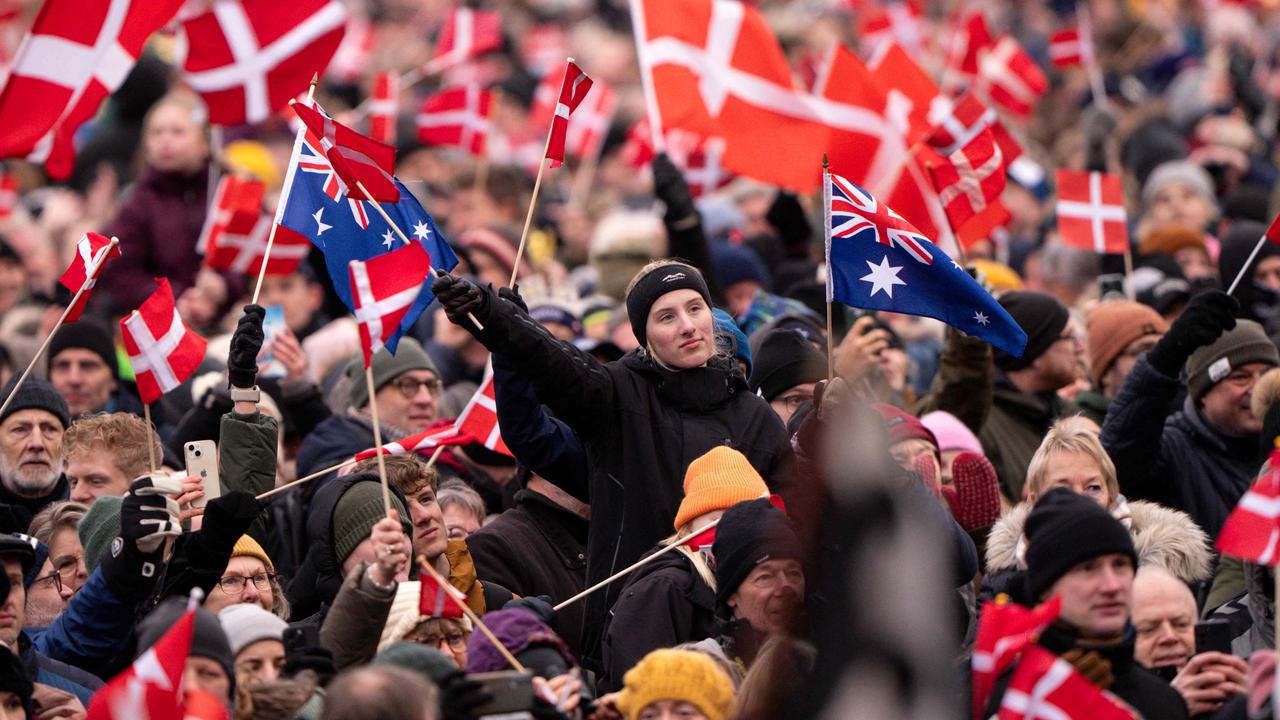 A wellwisher waves Australian flags among a sea of Danish flags in the crowd outside Christiansborg Palace. Picture: Bo Amstrup / Ritzau Scanpix / AFP