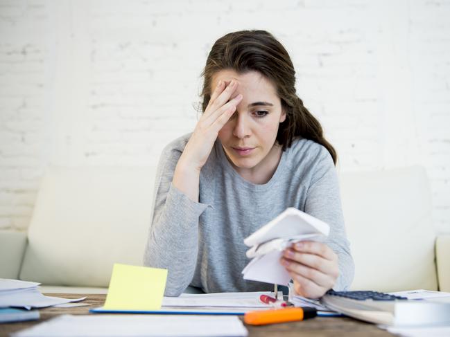 MONEY ISTOCK -  young attractive and desperate woman suffering stress doing domestic accounting paperwork bills and invoices worried and stressed at home sofa couch with bank folders and receipts Picture: Istock