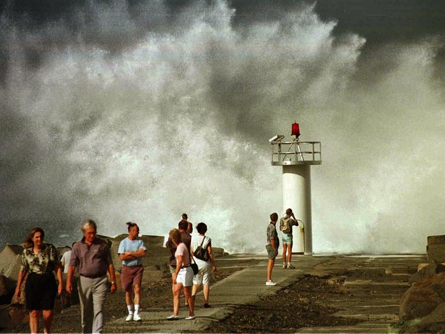 Waves crash into the Seawall.
