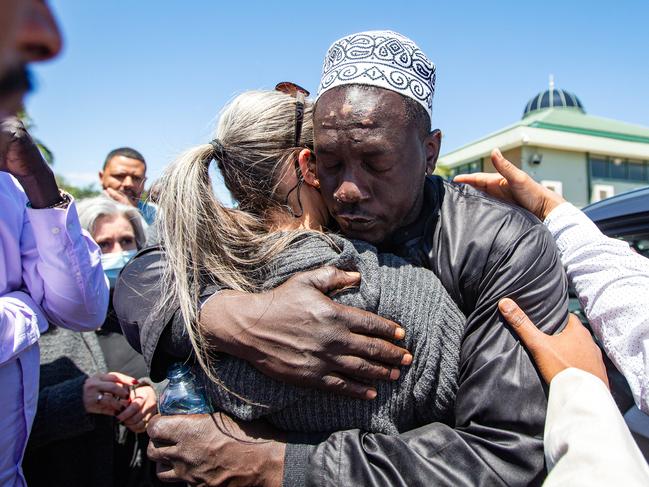 The children’s father, Nagmeldin Osman, is comforted outside at Al-Taqwa Mosque. Picture: Sarah Matray