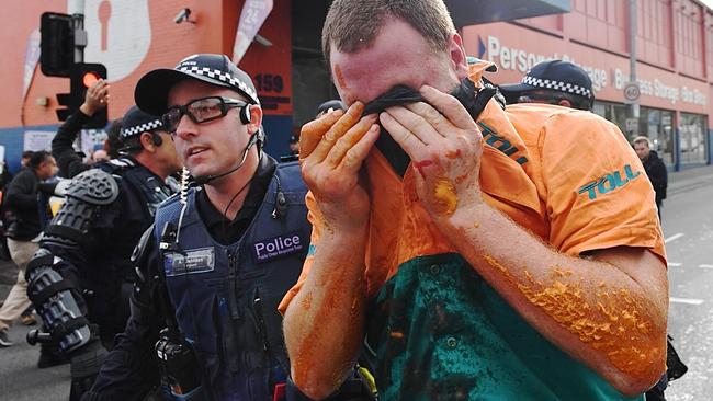 A right-wing protester covers his eyes after being pepper sprayed. Picture: Jake Nowakowski