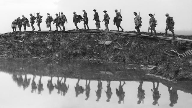 Supporting troops of the 1st Australian Division walking on a duckboardtrack near Hooge, in the Ypres Sector. Picture: Frank Hurley / Australian War Memorial.
