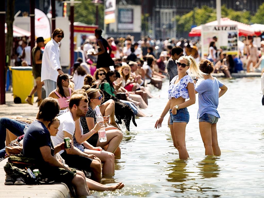 People cool off in a fountain on Museum square in Amsterdam, the Netherlands, on July 1, 2015, on a hot summer day. A blistering heatwave sweeping through Europe on July 1 brought blackouts to France and fears of heat stroke for Wimbledon tennis fans. Picture: AFP